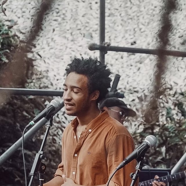 Luke singing into a microphone at an outdoor gig